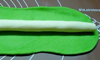Выложите белый валик на зеленый пласт и немного приплющите.