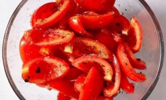 Положите кусочки помидоров в большую миску и сбрызните оливковым маслом и приправами