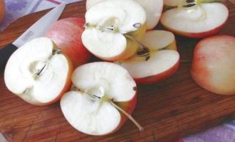 После первичной обработки, яблоки разрезать на две части.