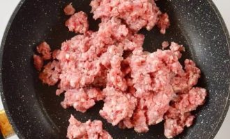 Возьмите готовый свиной фарш и выложите на сковородку.
